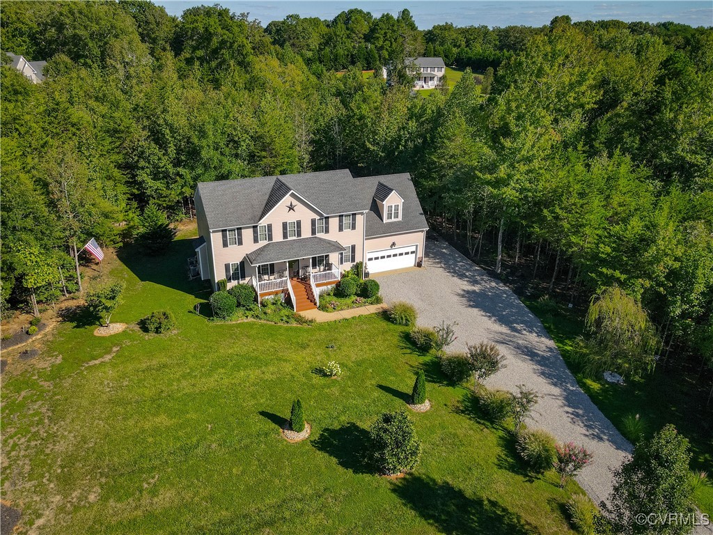 an aerial view of a house with a big yard and large trees