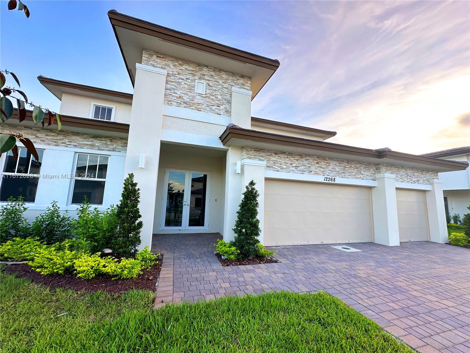 a front view of a house with a yard and garage