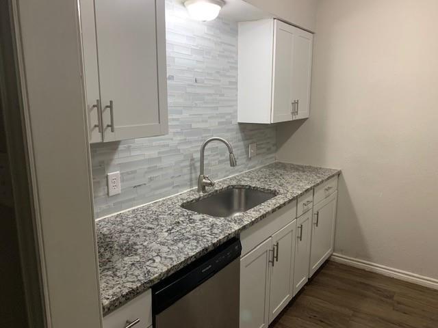 a kitchen with granite countertop a sink and cabinets