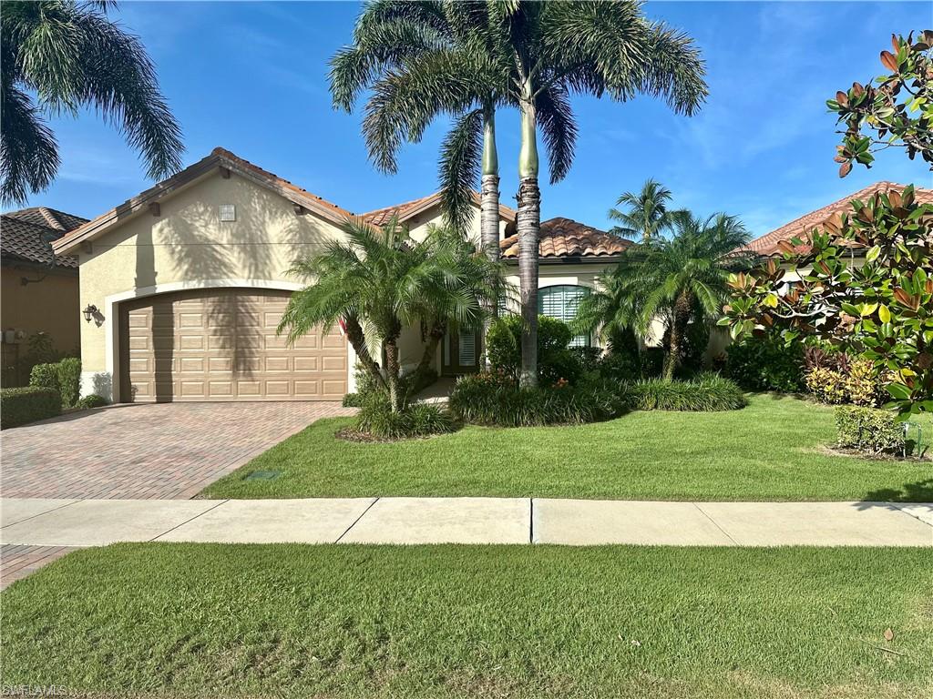 a view of a house with a yard and palm trees