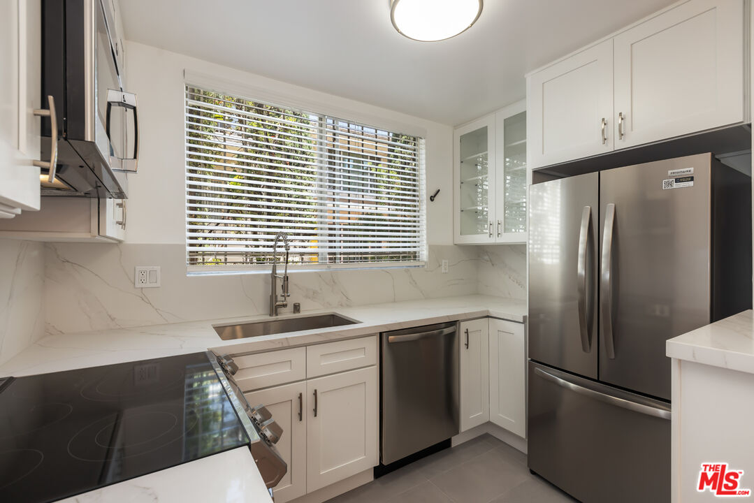 a kitchen with white cabinets and a refrigerator