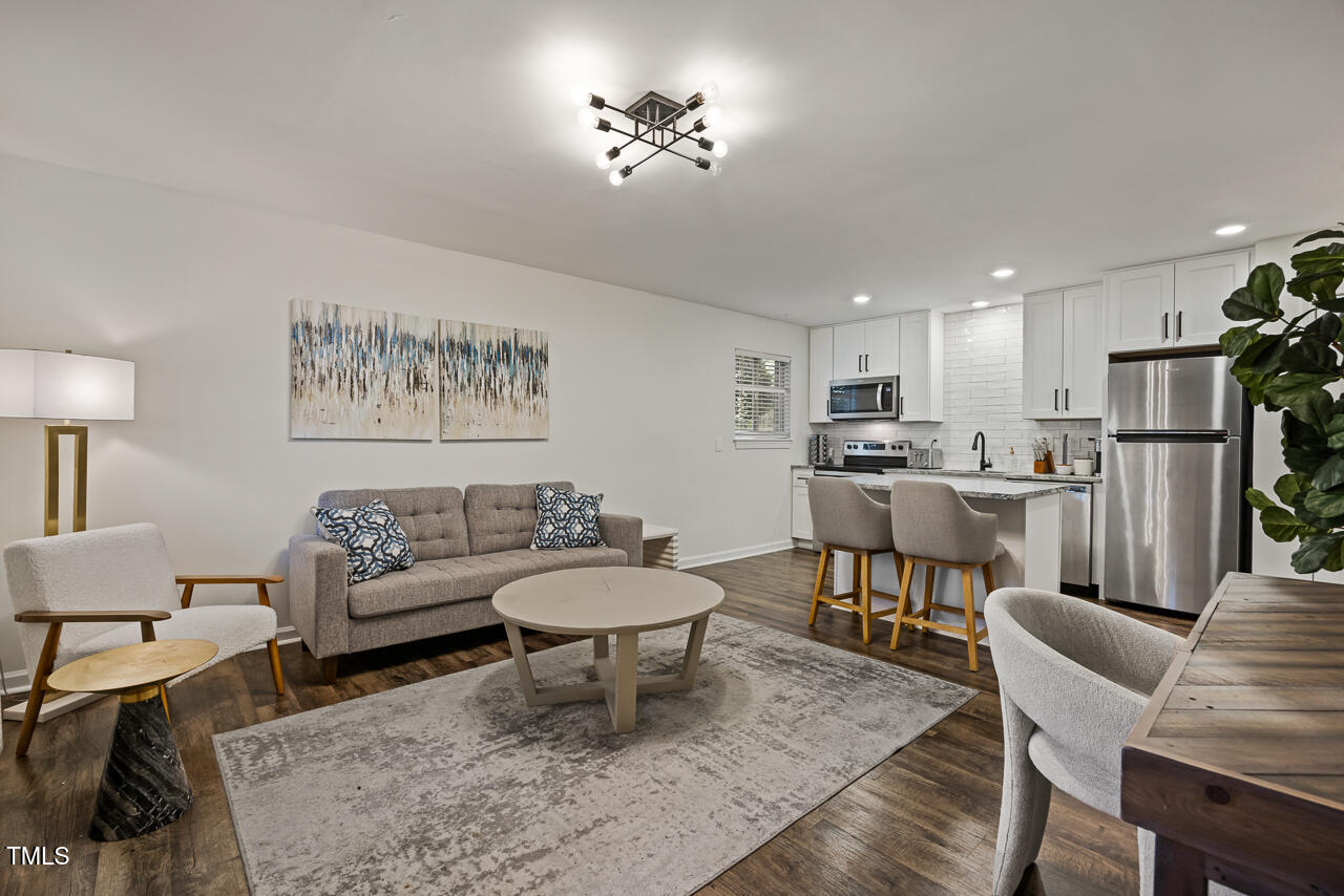 a living room with furniture and a dining table with kitchen view