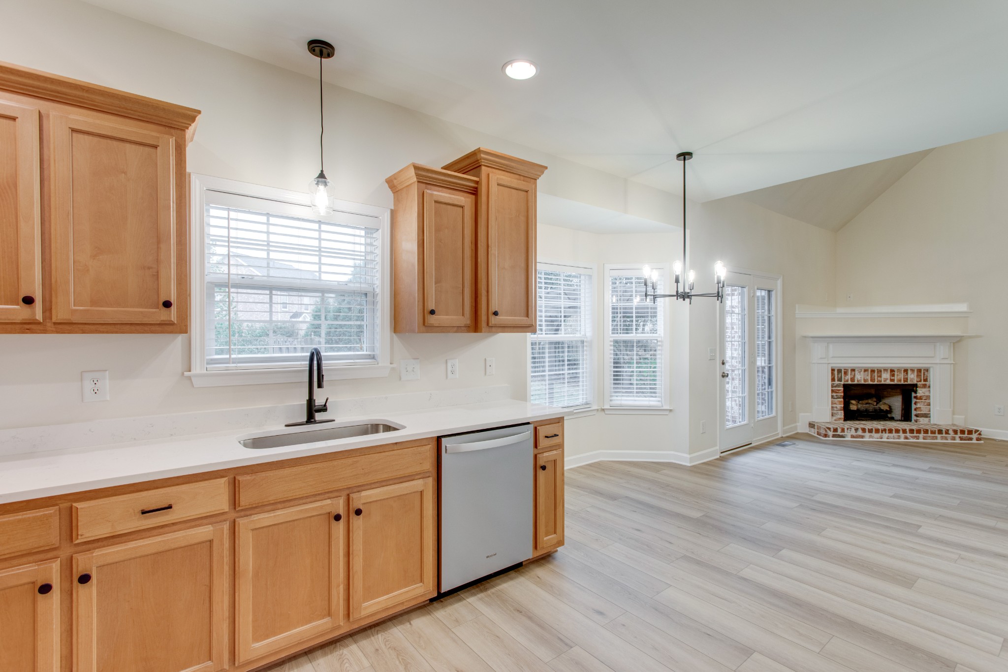 a kitchen with granite countertop a sink a counter space appliances and cabinets