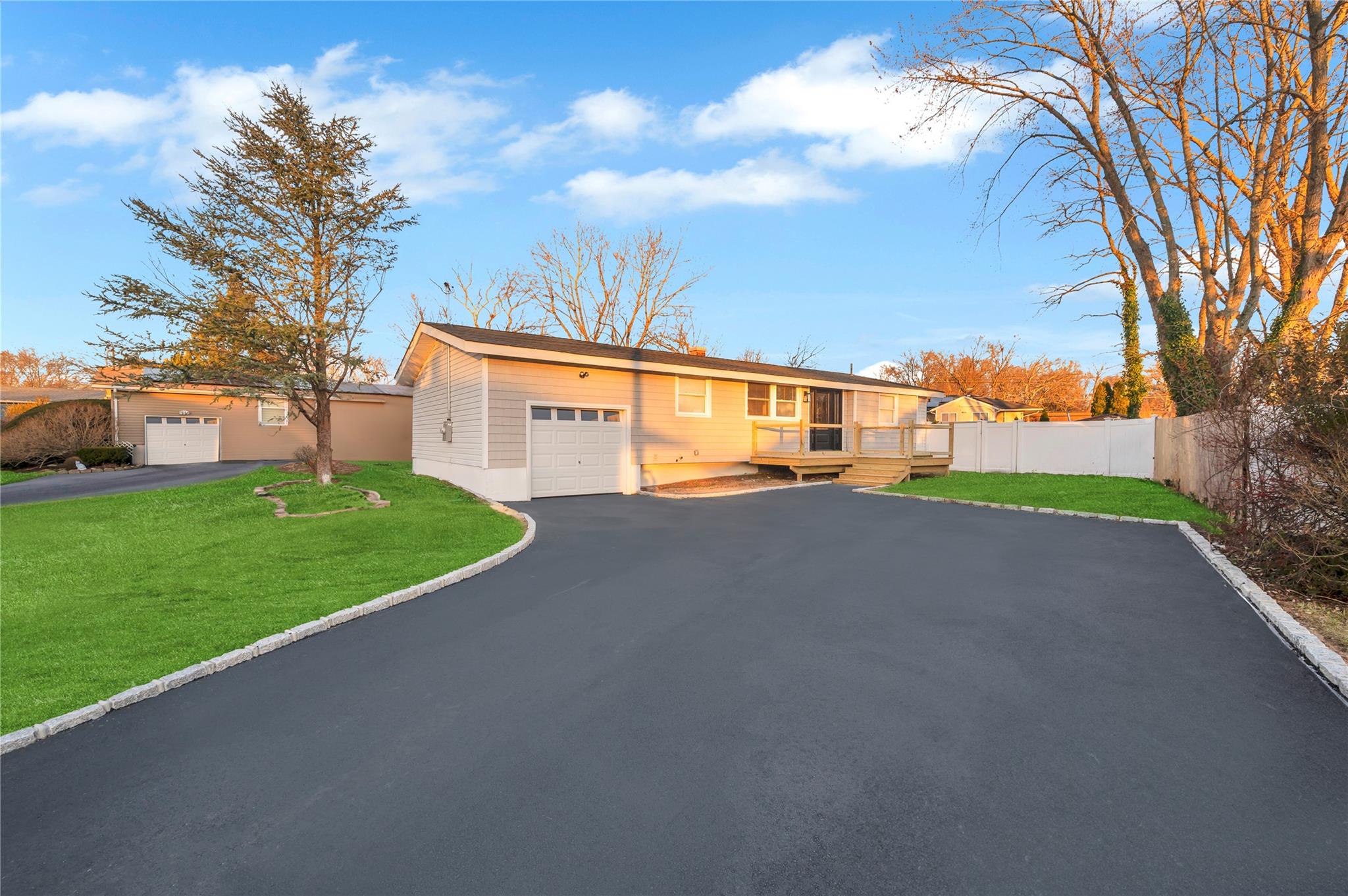 View of front facade featuring a garage, a front yard, and a deck