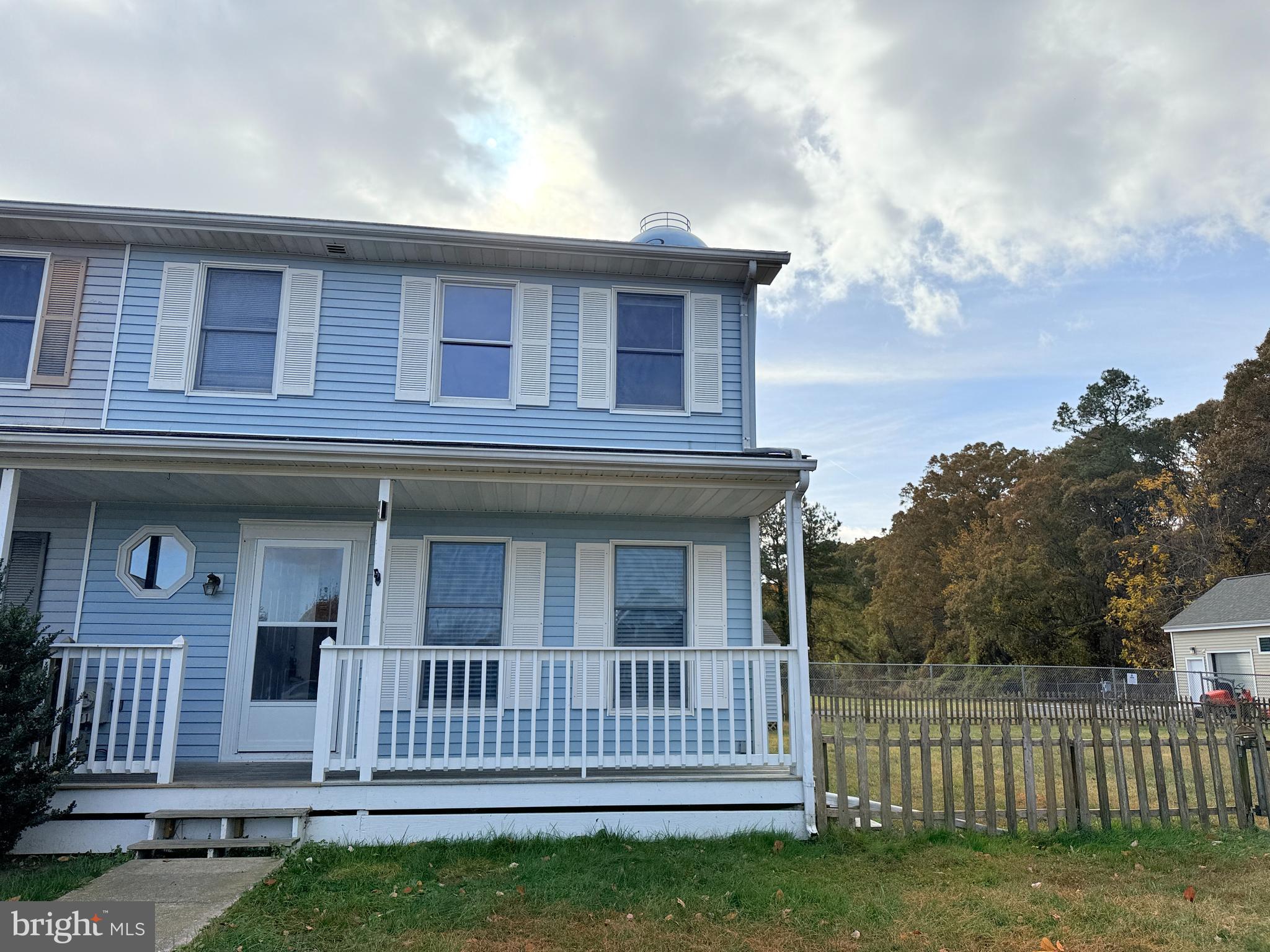 a view of a house with a small yard and wooden fence