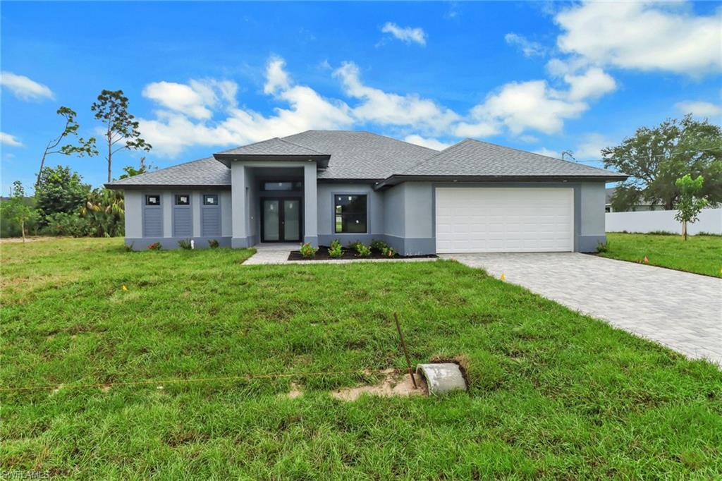 a front view of a house with a yard and garage