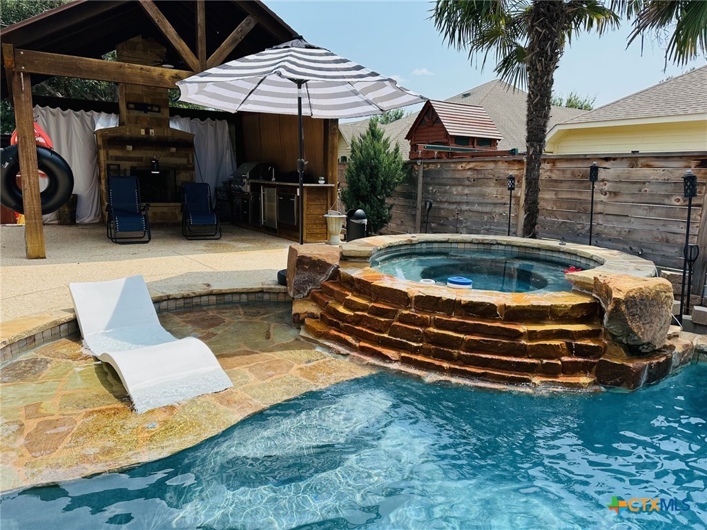 a backyard of a house with barbeque oven table and chairs