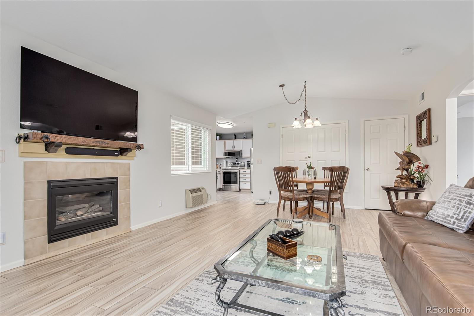 a living room with furniture a flat screen tv and a fireplace