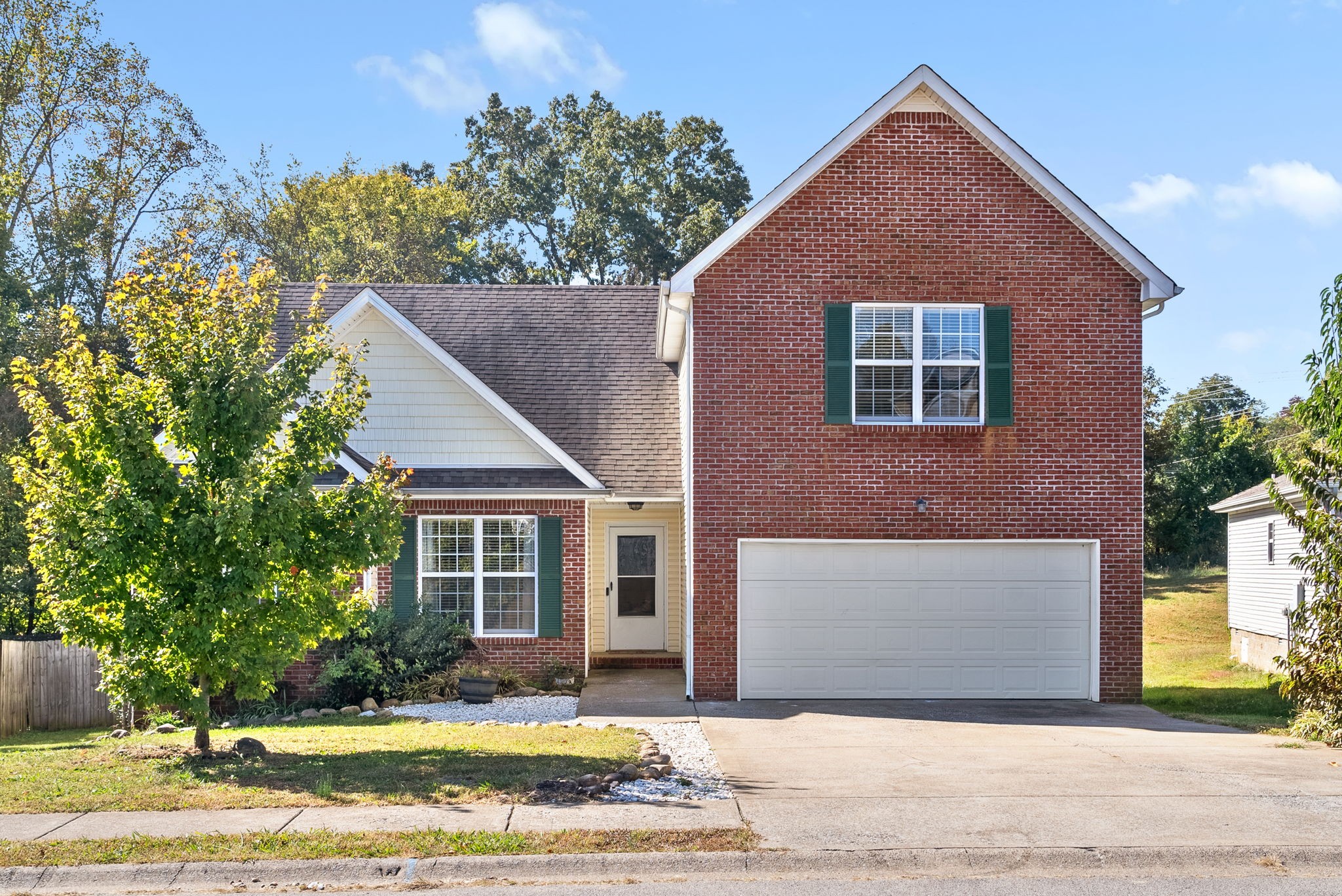 a front view of a house with a yard and trees