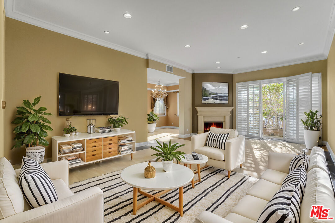 a living room with furniture flat screen tv and a large window