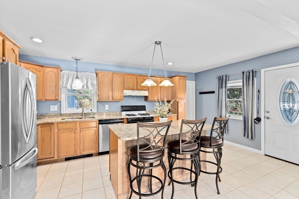 a kitchen with stainless steel appliances a table chairs and a refrigerator