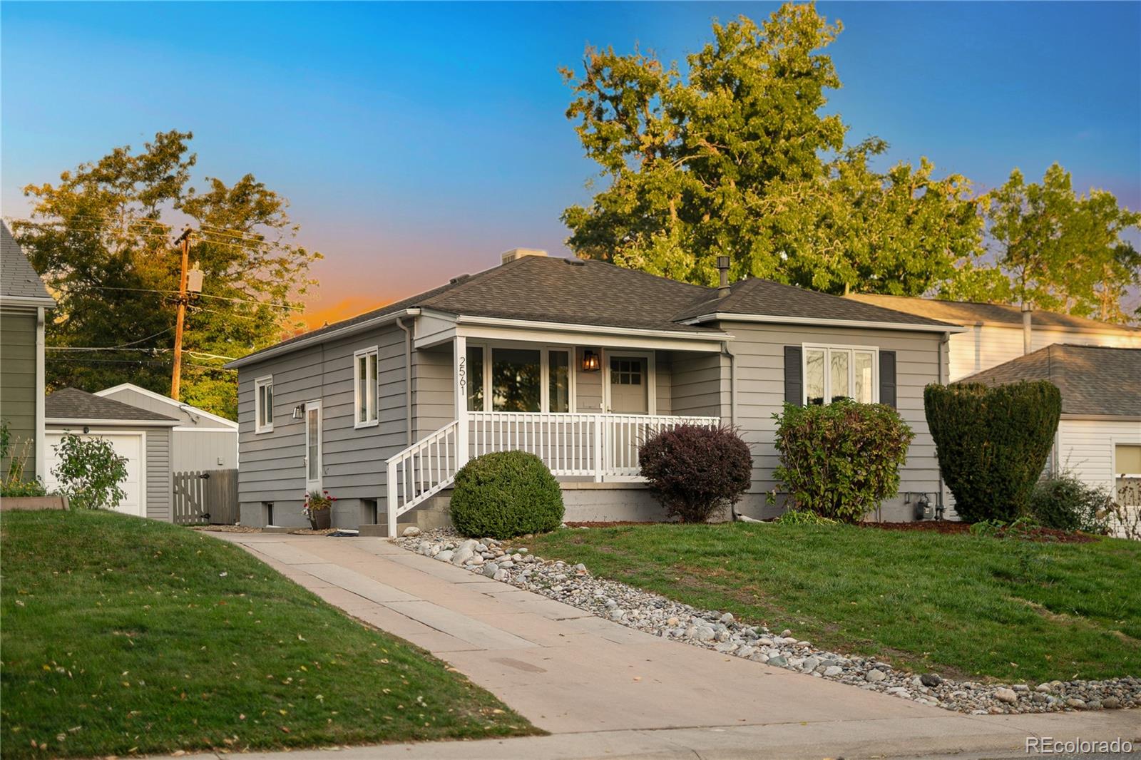 a front view of a house with a garden and plants