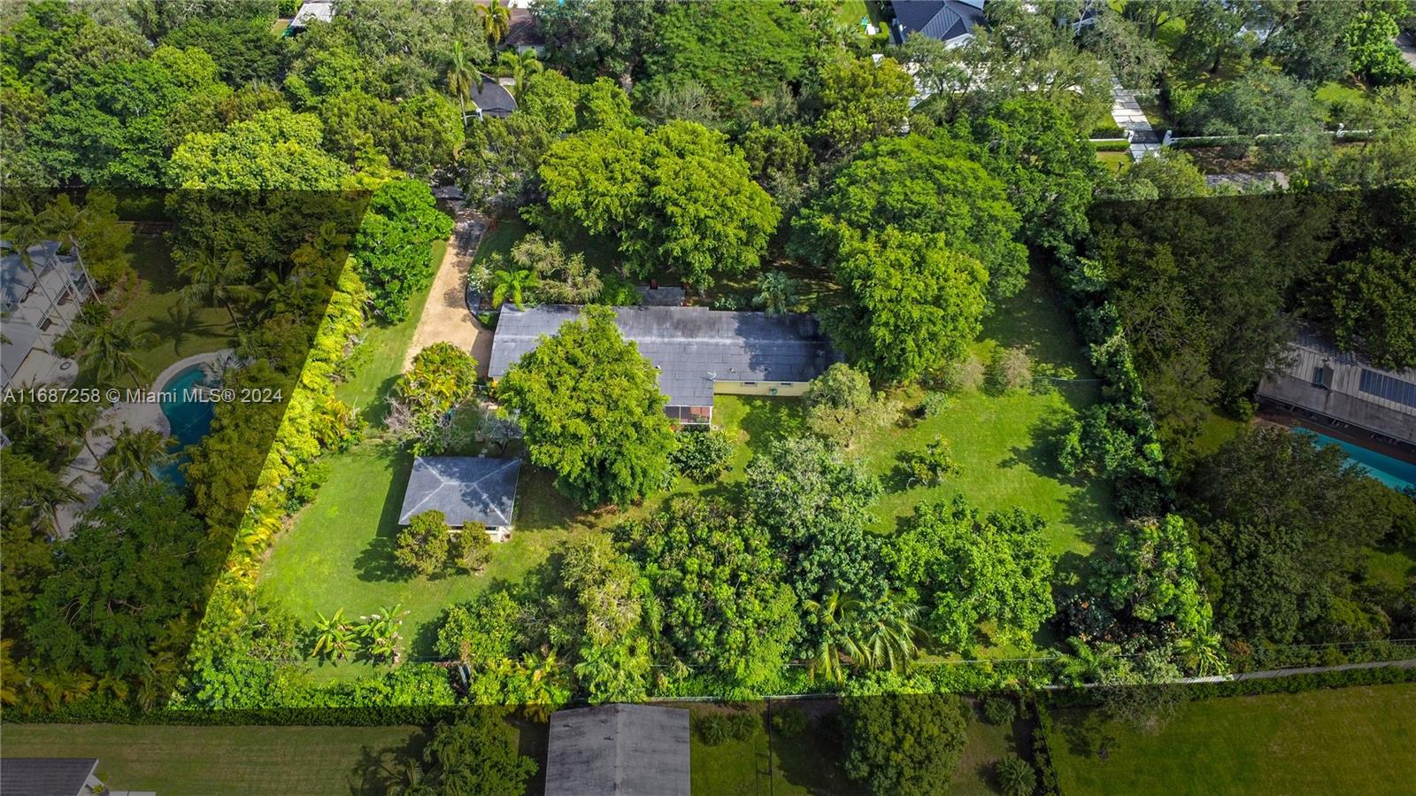 an aerial view of residential house with outdoor space and trees all around