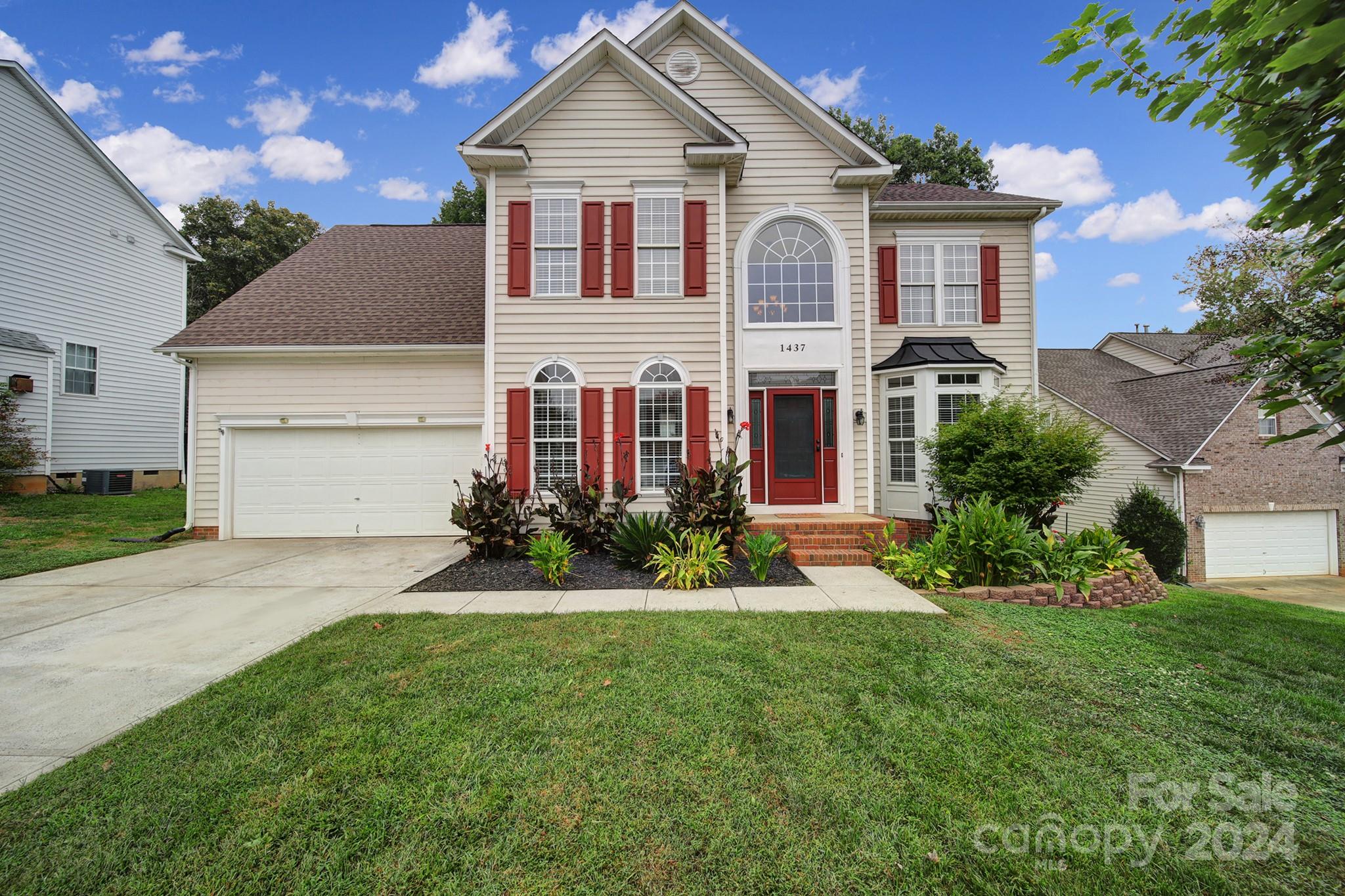 a front view of a house with a yard and garage