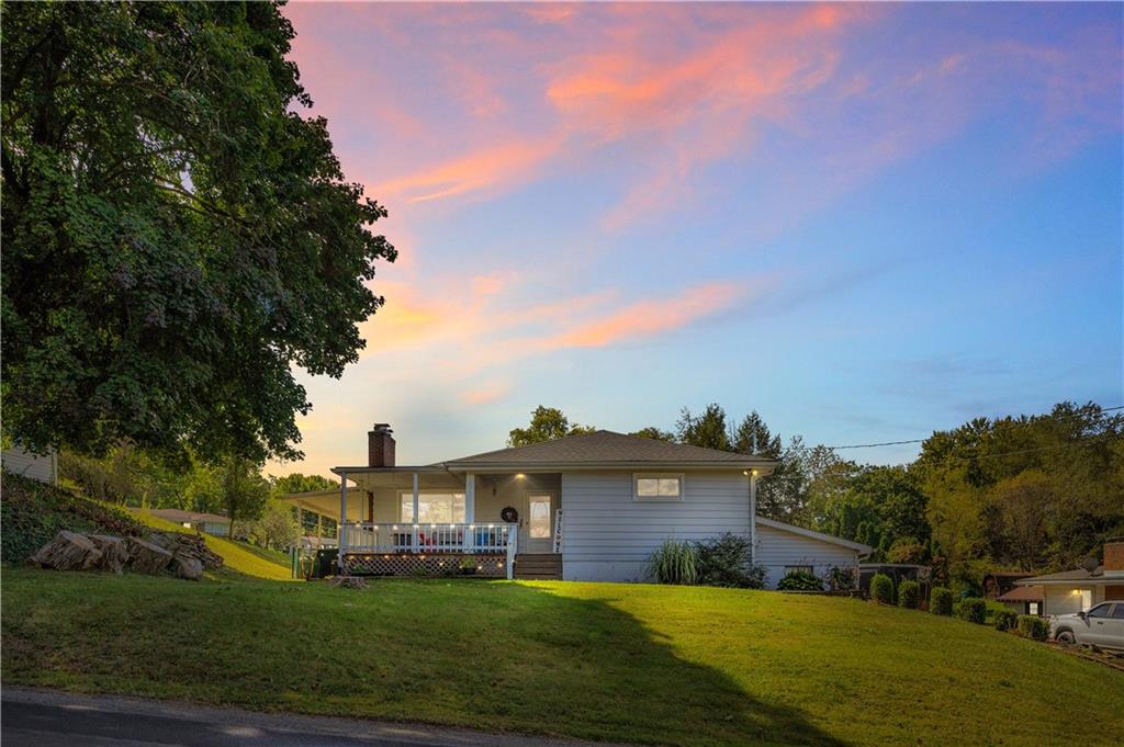 a view of a house with a big yard and large trees