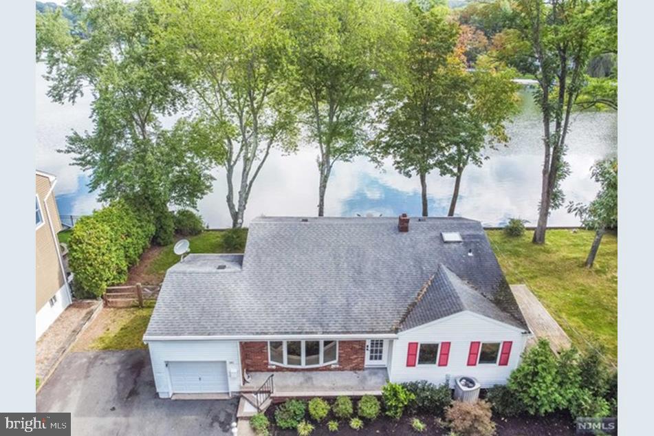 an aerial view of house with yard and trees in the background