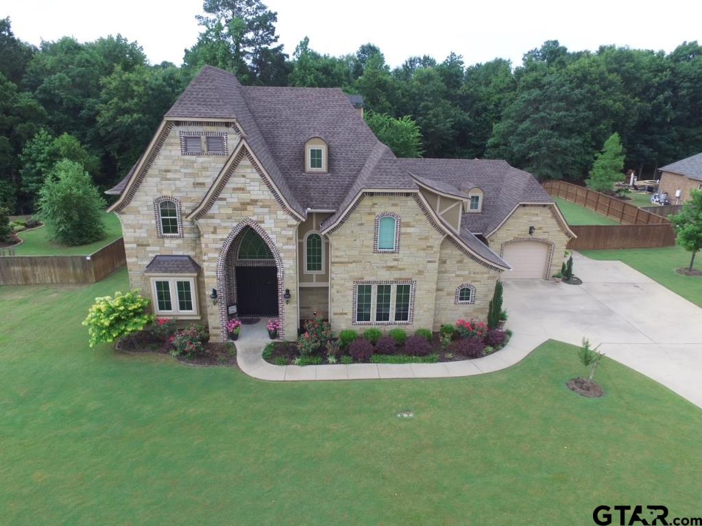 a aerial view of a house next to a big yard and large trees