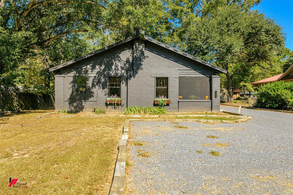 a view of a house with backyard and sitting area