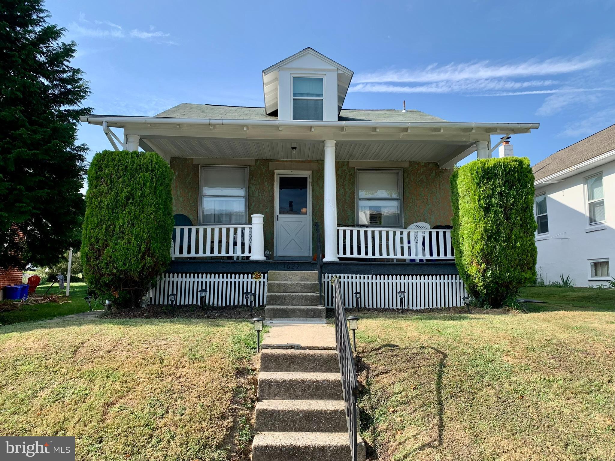 a front view of a house with a garden