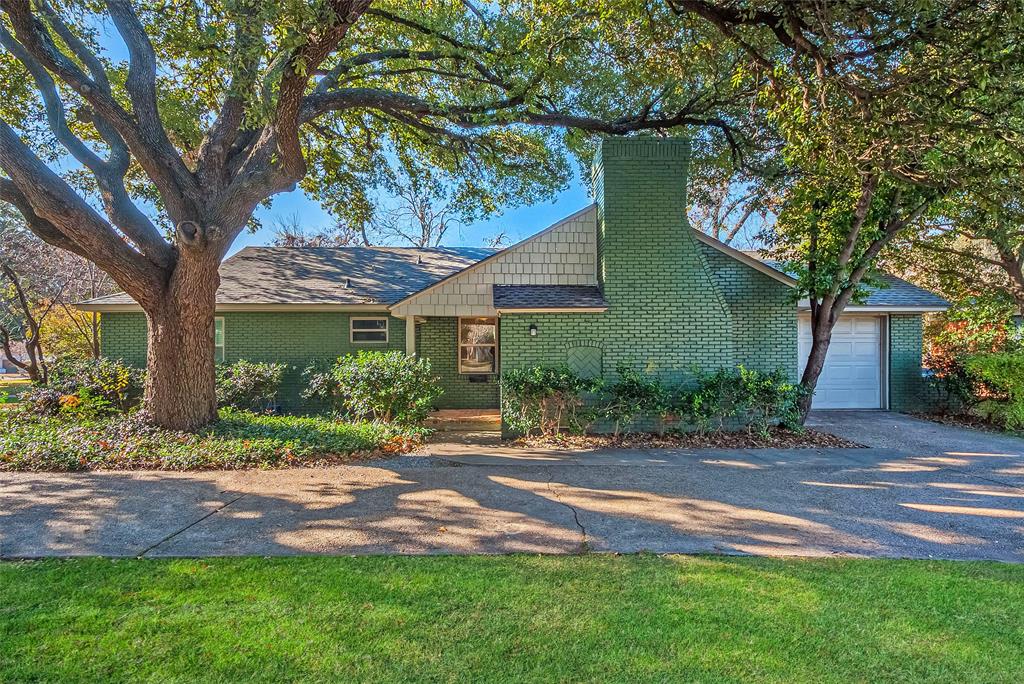 a front view of a house with a yard and potted plants