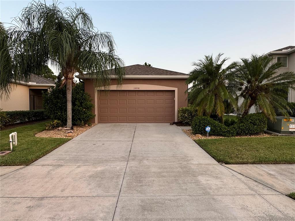 a front view of a house with a yard and palm trees