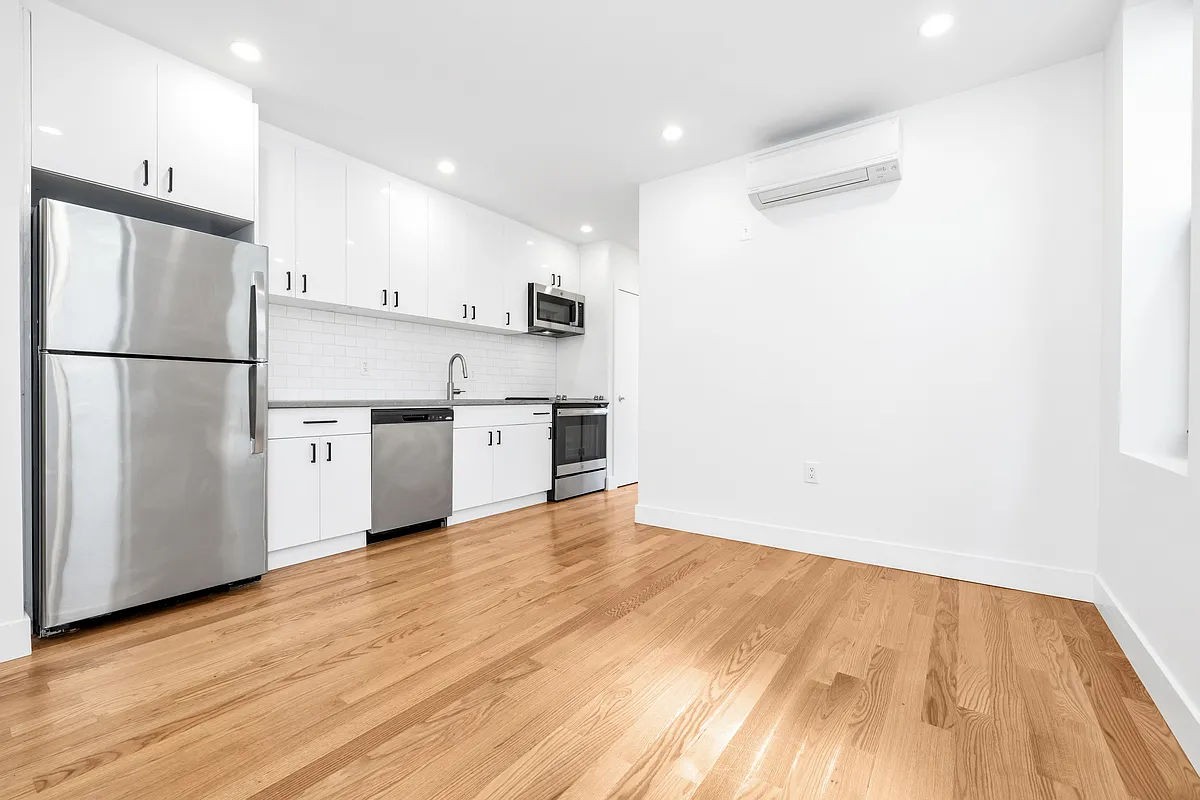 a view of a kitchen with a sink and a refrigerator