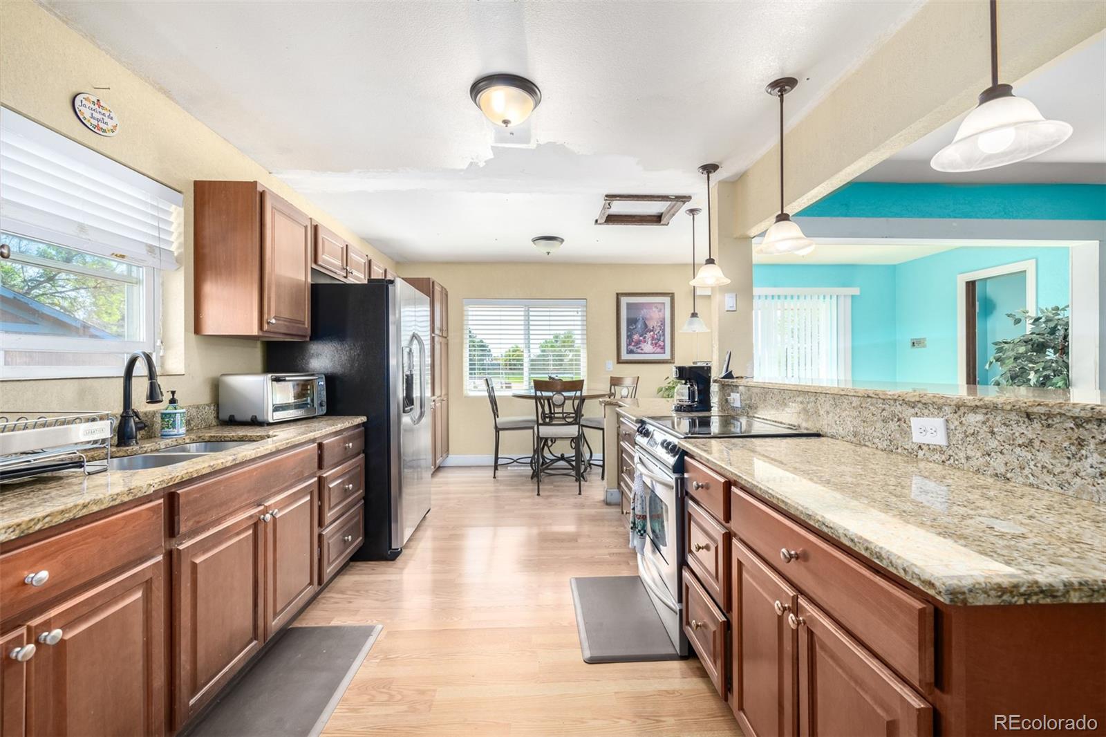 a kitchen with stainless steel appliances granite countertop sink stove top oven and cabinets