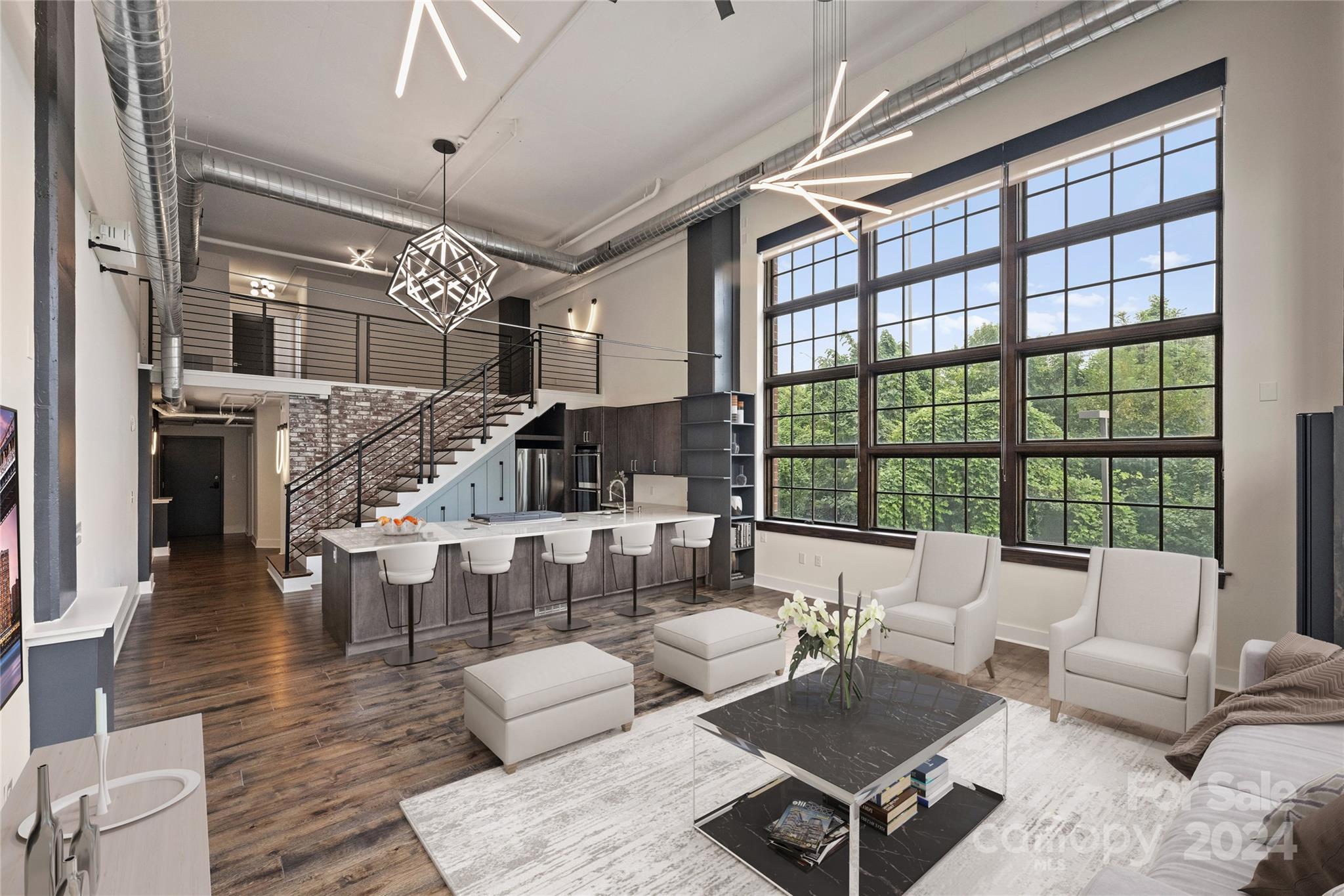 a living room with furniture large windows and wooden floor