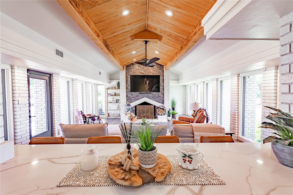 a living room with furniture a fireplace and large windows