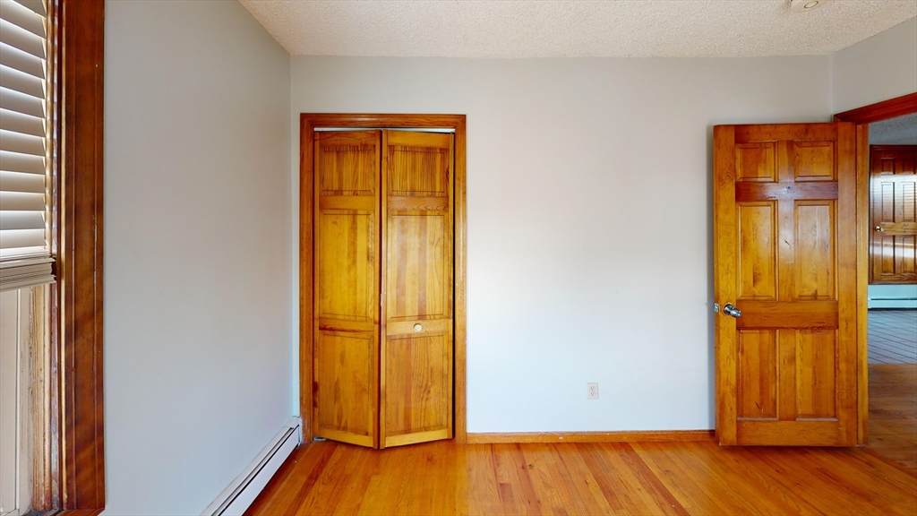 an empty room with wooden floor and a window