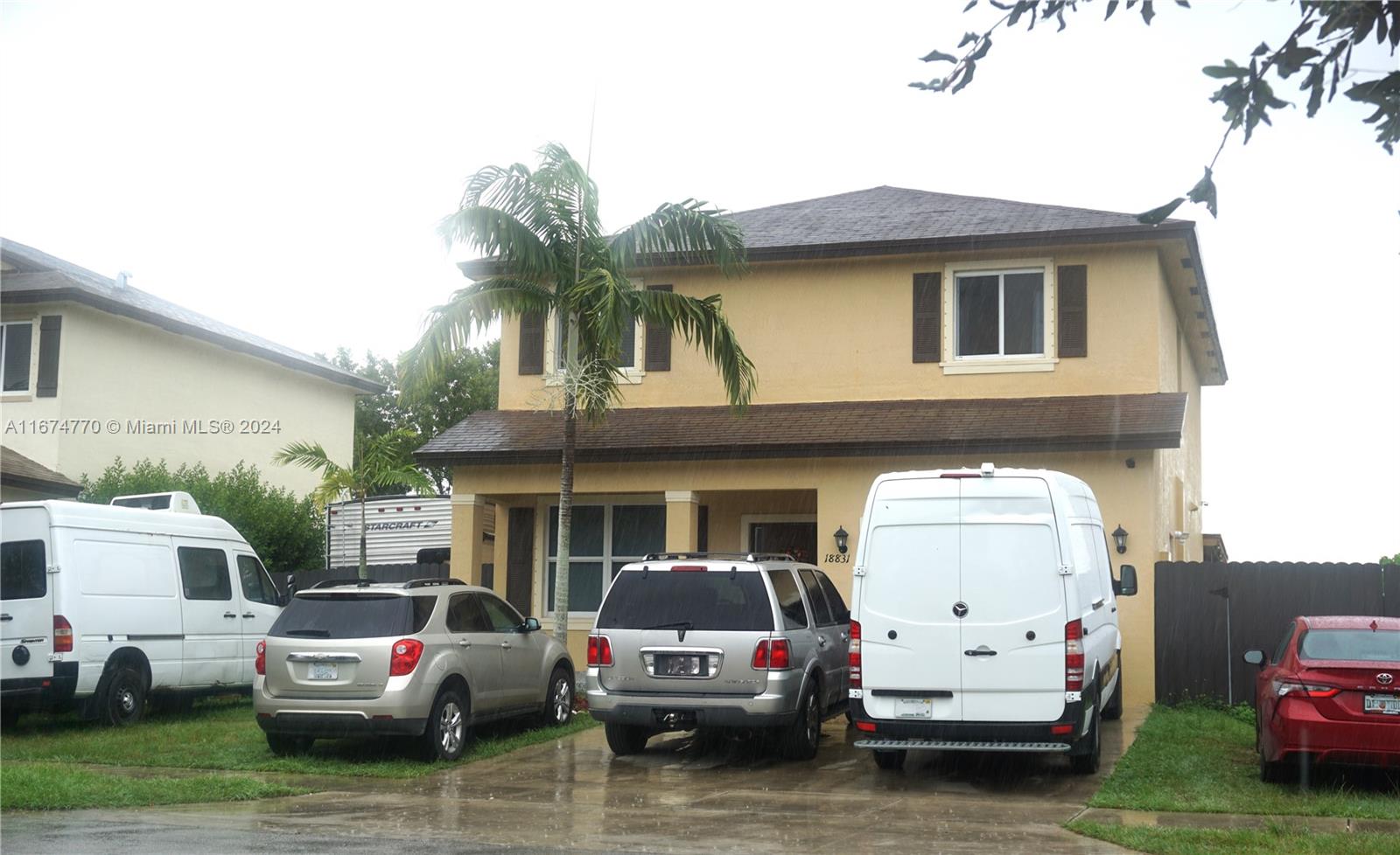 a front view of a house with cars parked