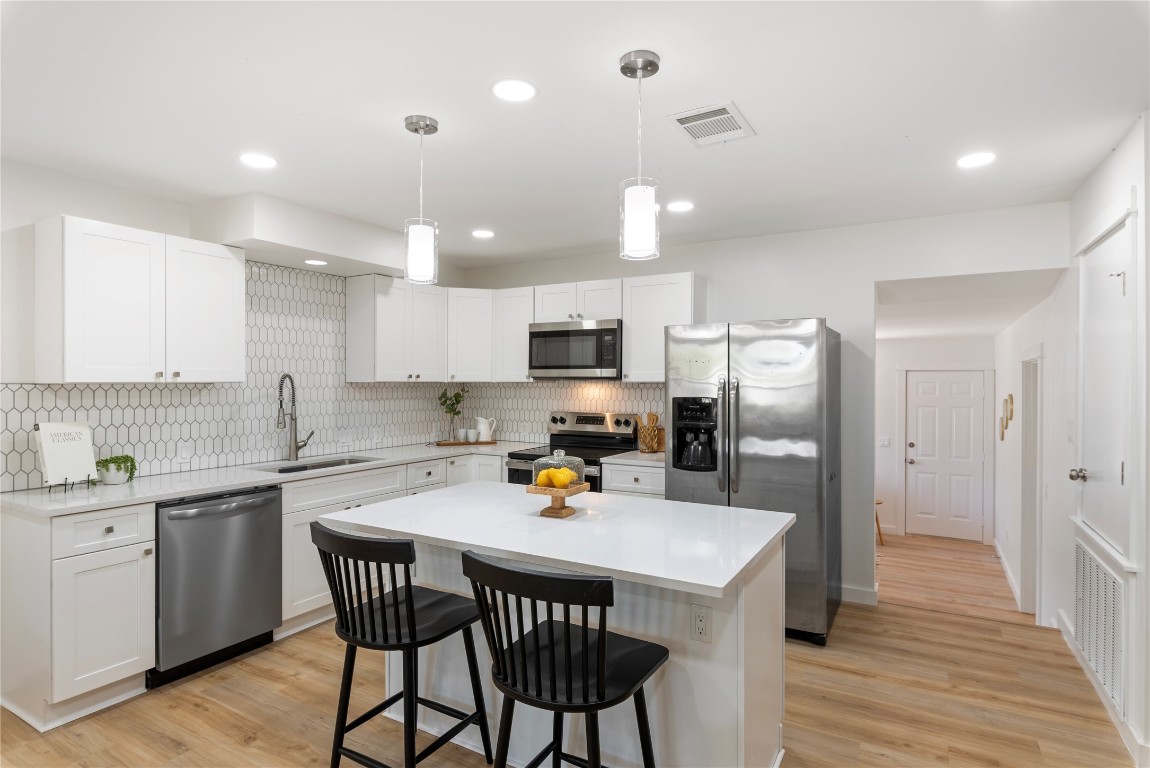 a kitchen that has a lot of cabinets a sink and appliances in it