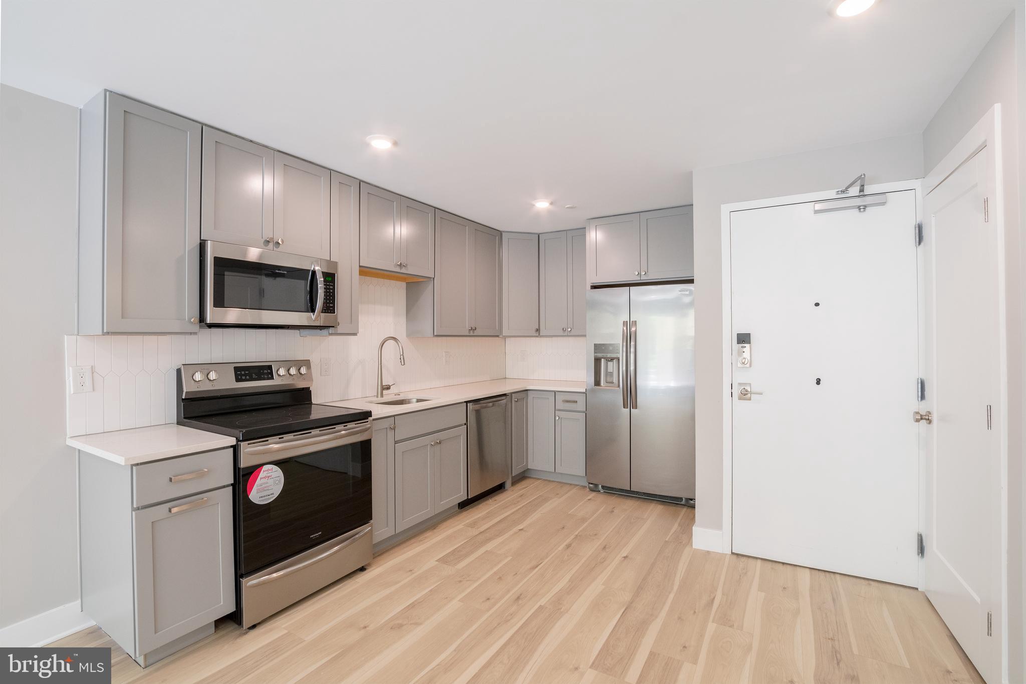 a kitchen with a sink a refrigerator a microwave oven and cabinets