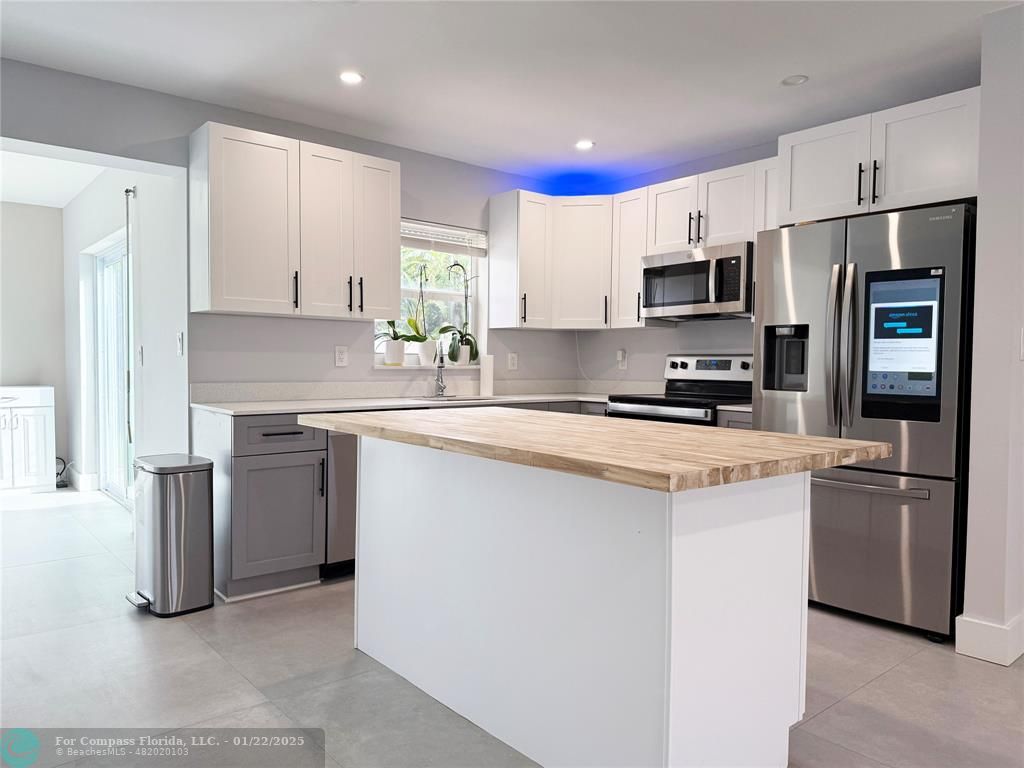 a kitchen with stainless steel appliances a refrigerator sink and microwave