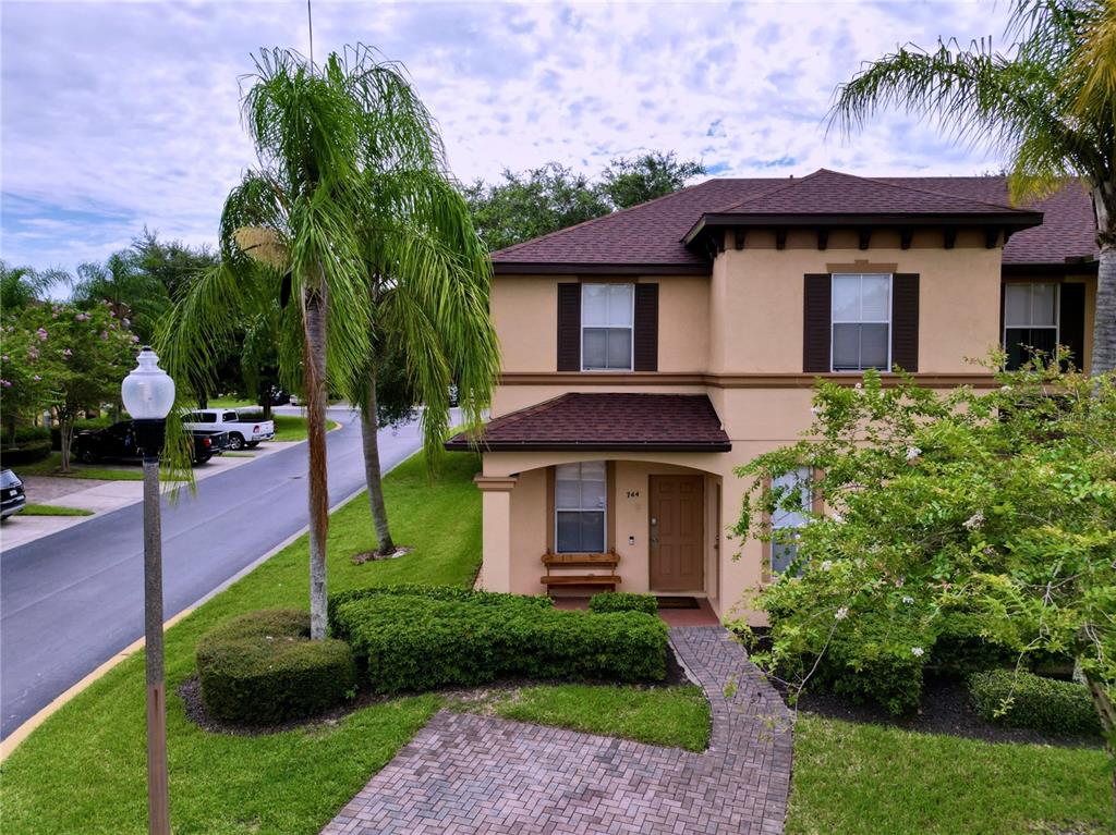 a front view of a house with a garden and trees