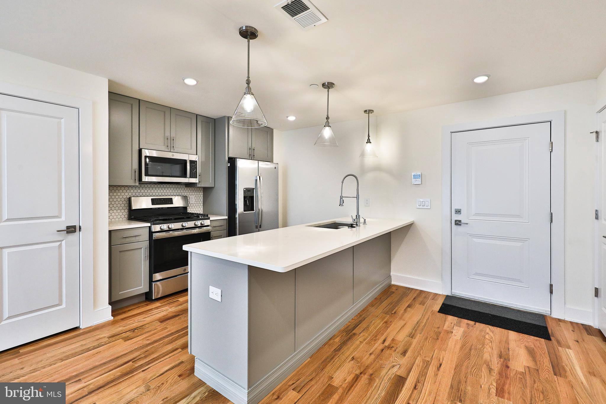 a kitchen with kitchen island a sink stainless steel appliances and cabinets