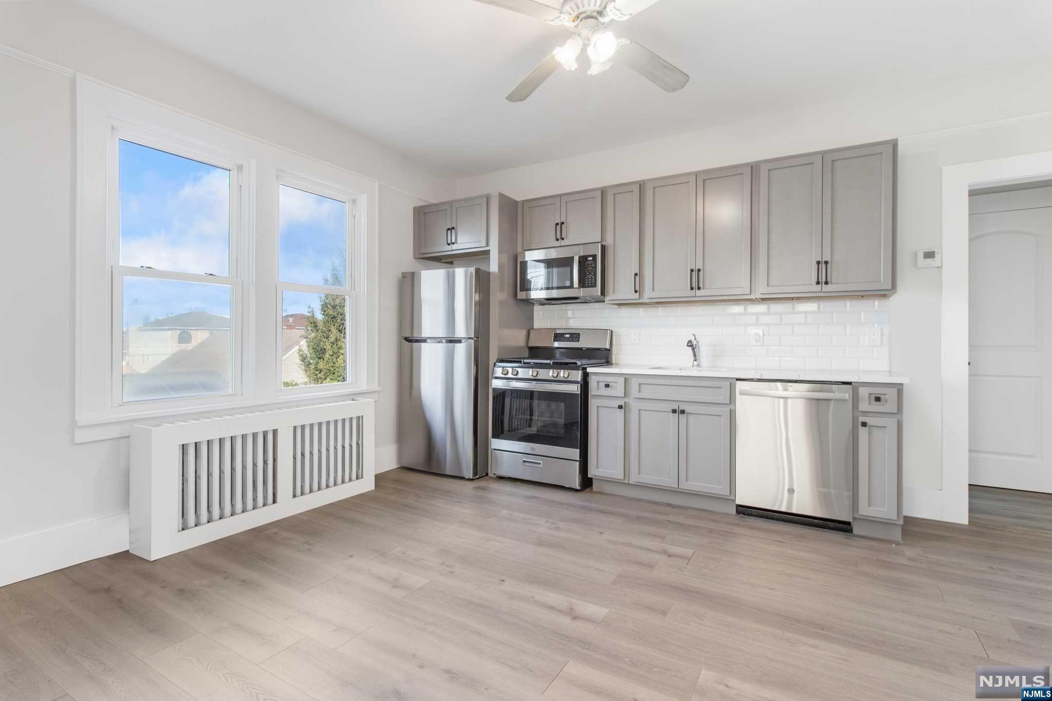 a kitchen with white cabinets and appliances