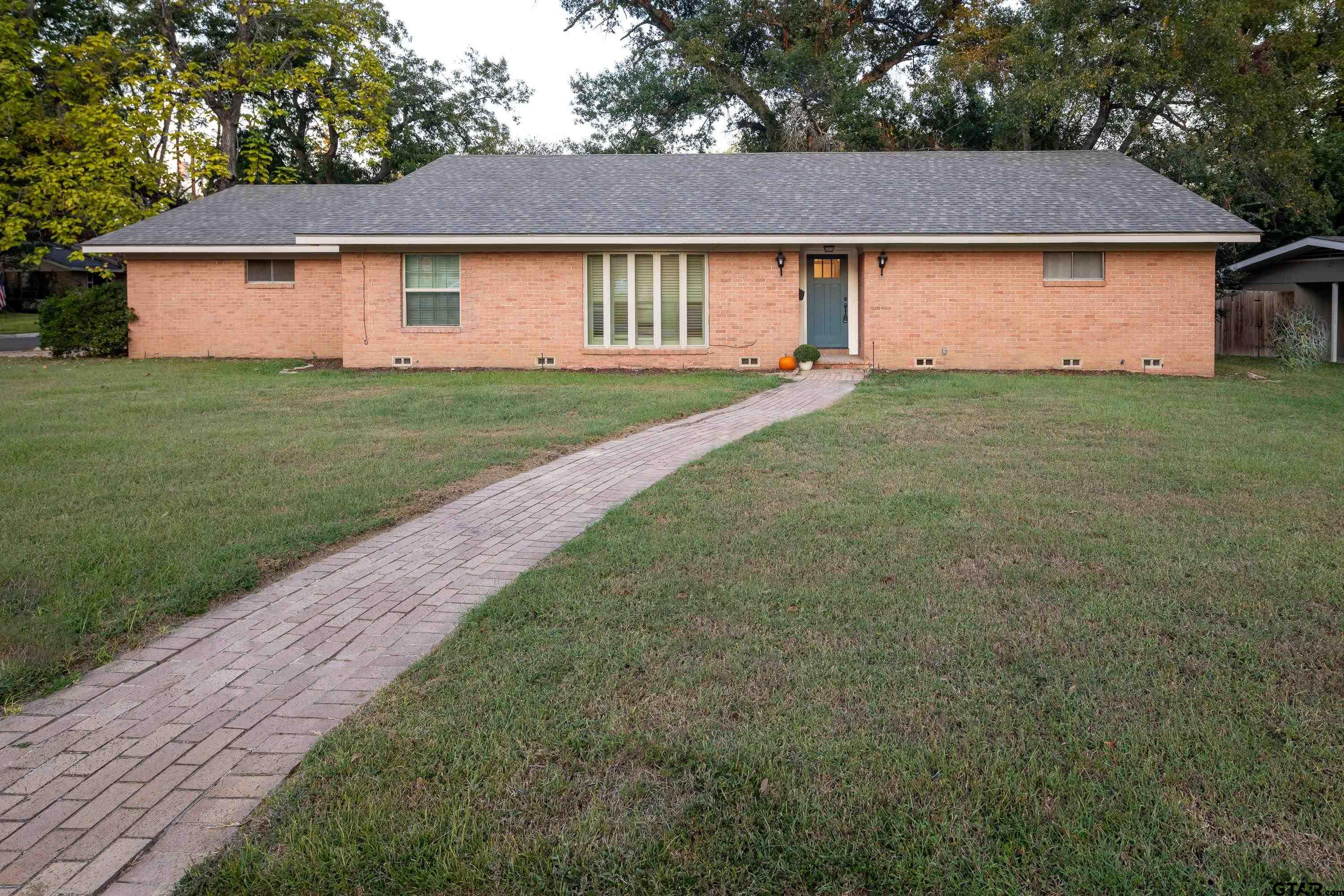 a view of backyard of house with green space