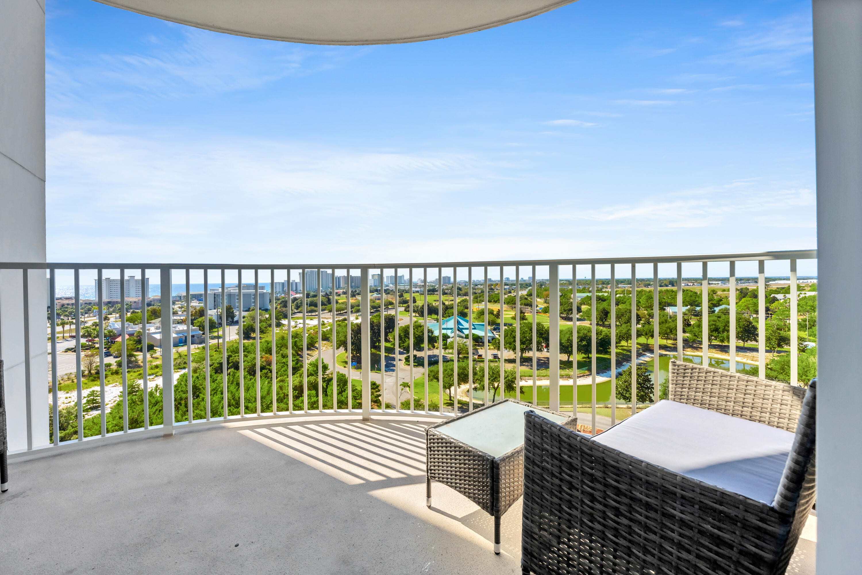 a balcony with a floor to ceiling window next to a yard