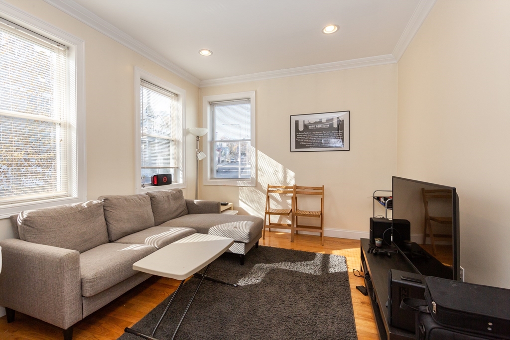 a living room with furniture a flat screen tv and a window