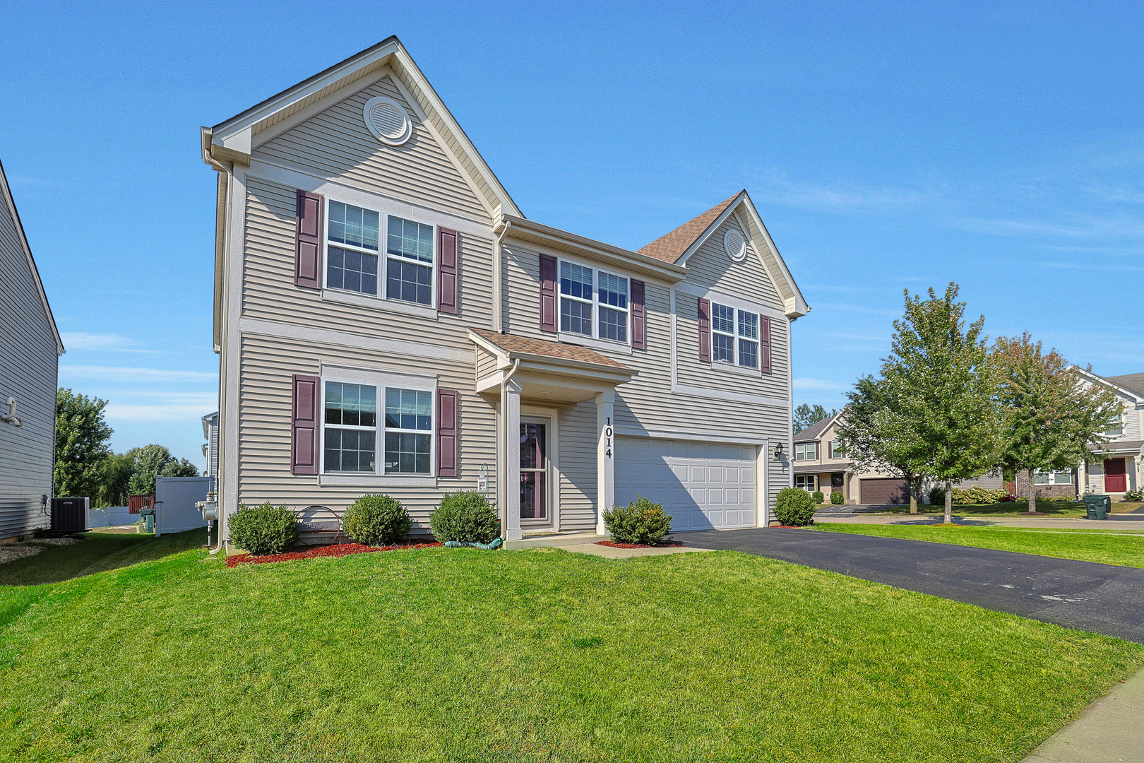 a front view of a house with a yard and trees