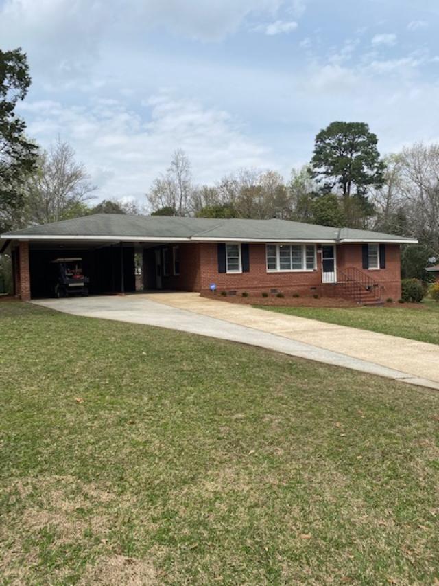 view of house with swimming pool and yard