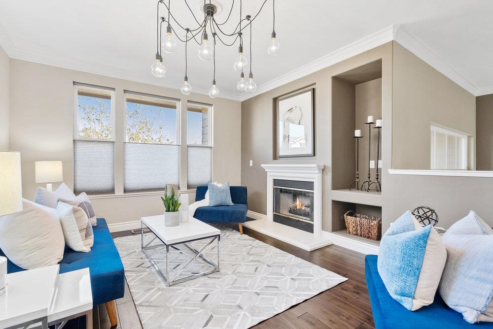 a living room with furniture a fireplace and a chandelier