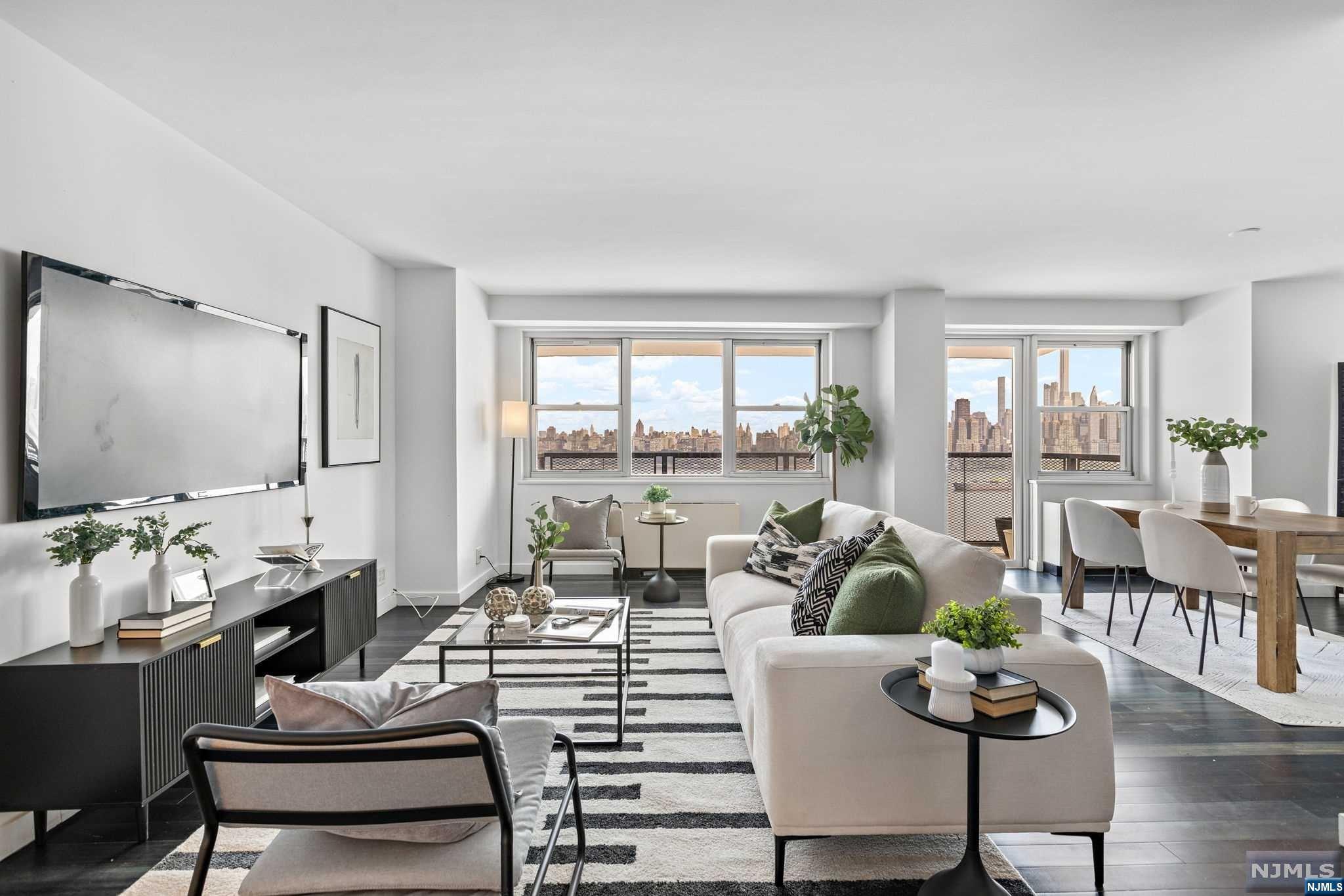 a living room with furniture large windows and wooden floor