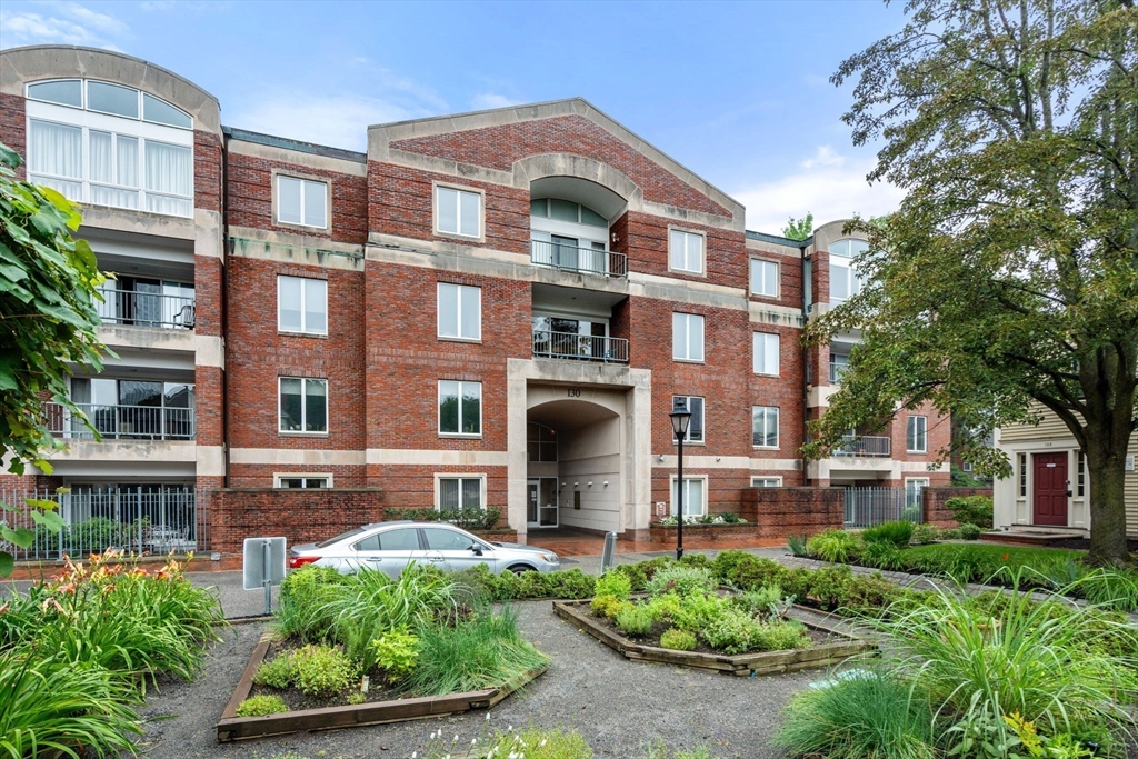 a front view of a residential apartment building with a yard