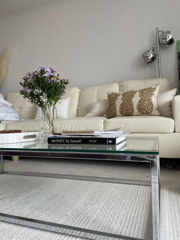 a view of a living room with a couch and a potted plant