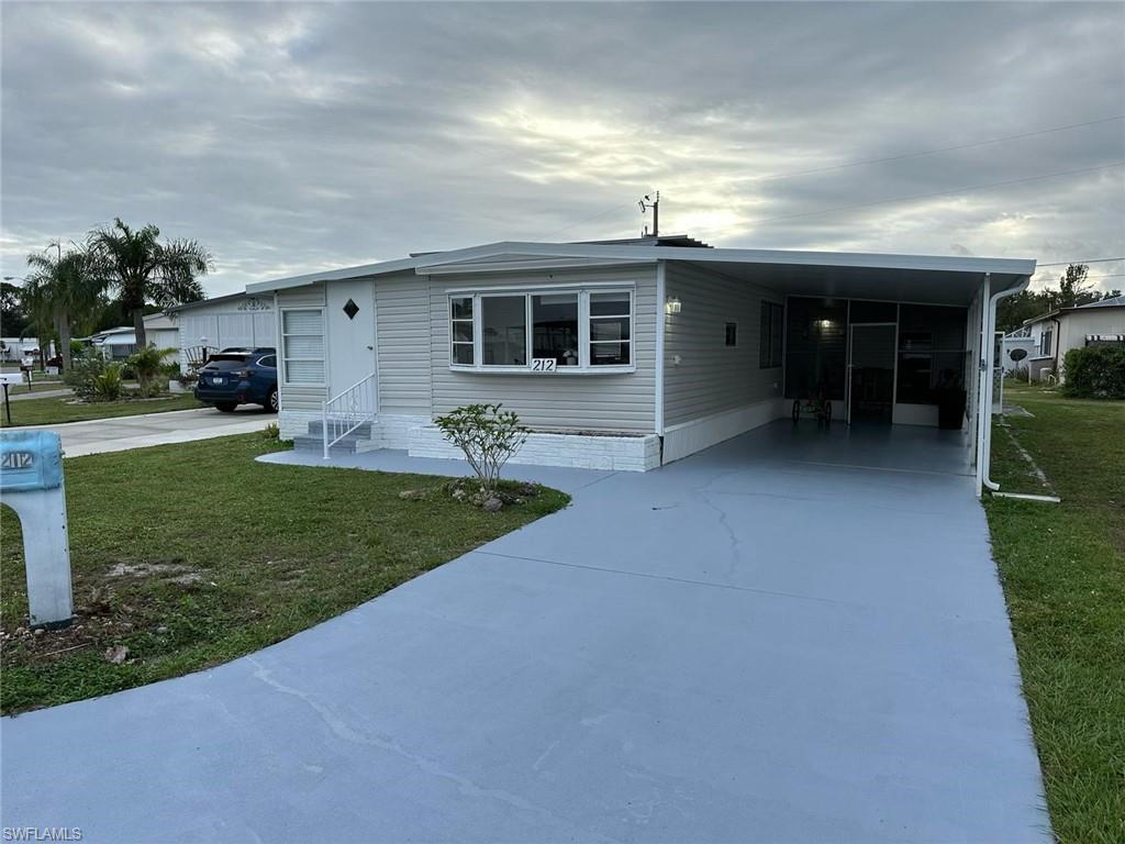 a view of a house with a yard and sitting area