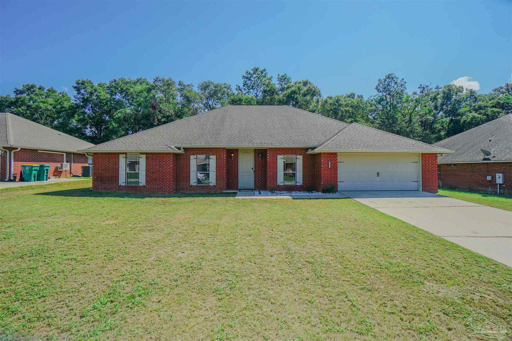 a front view of a house with yard and green space