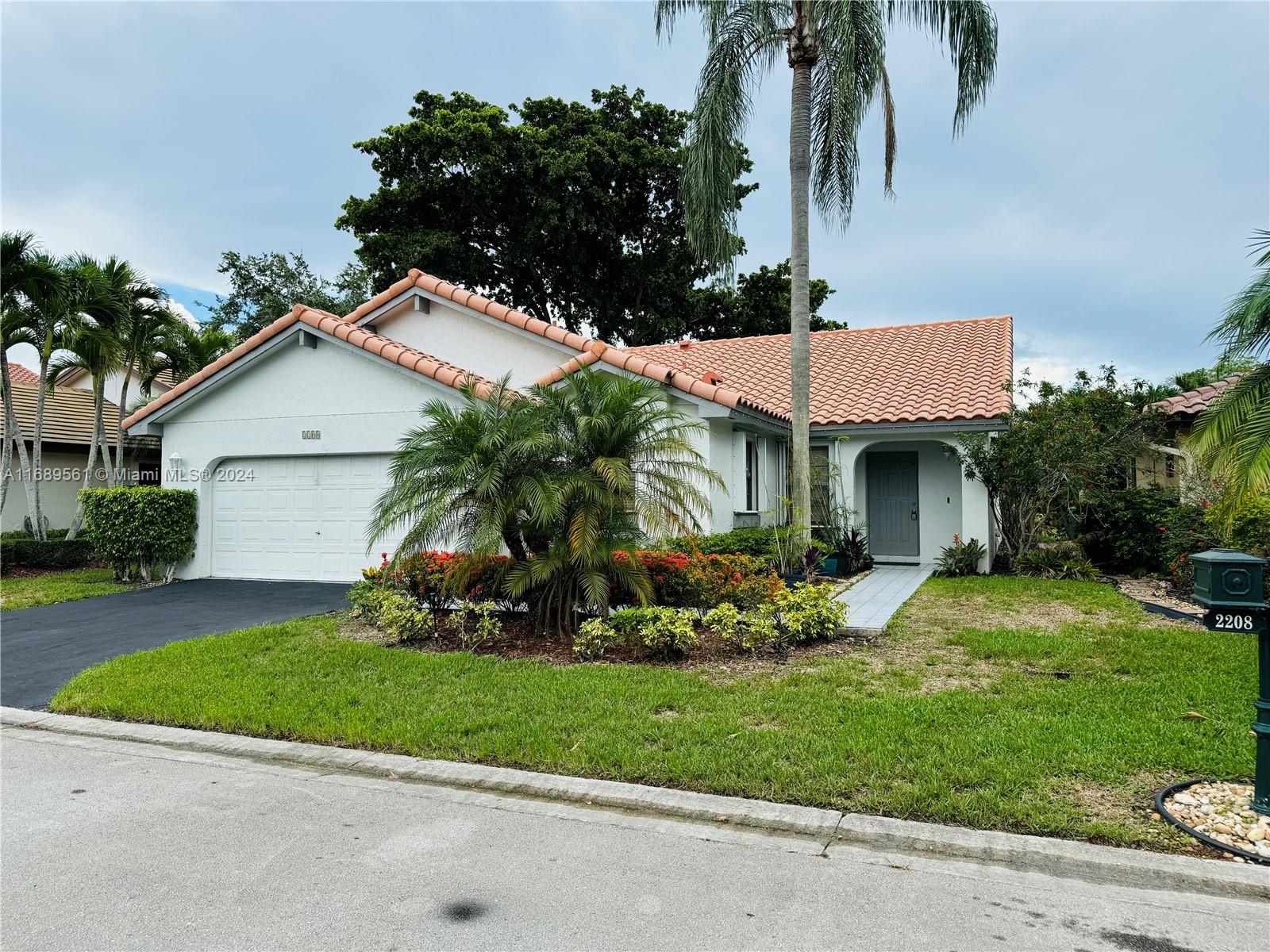 a front view of a house with a garden and plants