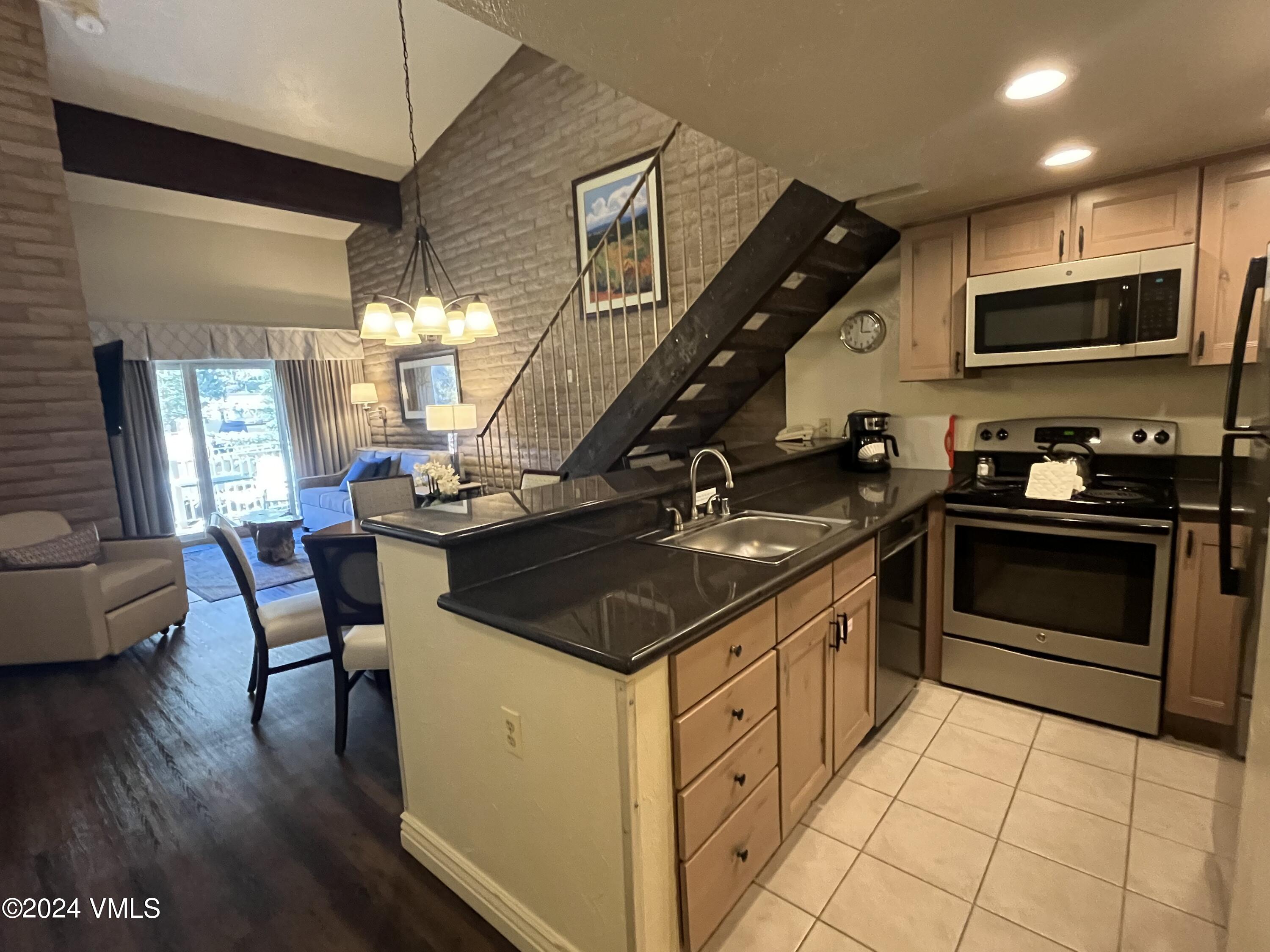 a kitchen that has a sink a stove and a wooden cabinets